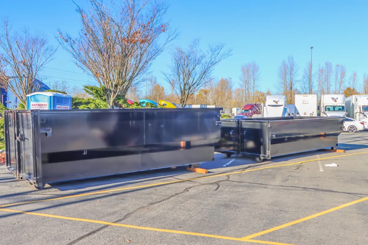 Professional dumpster rental service with roll-off container on residential driveway in Jonesboro